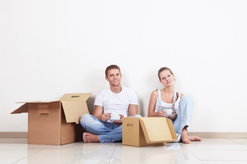 Professional movers carrying furniture on a local Enfield street